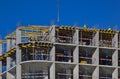 A group of high-rise assemblers work on the top floor of a construction site.