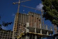 A group of high-rise assemblers work on the top floor of a construction site.