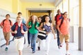 Group Of High School Students Running Along Corridor