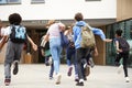 Group Of High School Students Running Into School Building At Beginning Of Class Royalty Free Stock Photo