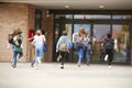 Group Of High School Students Running Into School Building At Beginning Of Class Royalty Free Stock Photo
