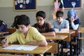 Group of high school students taking a test in classroom.