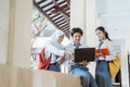 group of high school students using a laptop computer and carrying books wearing a school bag Royalty Free Stock Photo