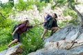 Group Hiker woman helping her friend climb up the last section of sunset in mountains. Traveler teamwork walking in outdoor lifest