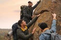 Group of hikers with backpacks climbing up mountains