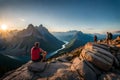 A group of hikers taking a break on a rocky outcrop, enjoying a breathtaking view of a mountain range in the distance