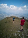 Group of hikers taking pictures in the high point with a beautiful view of mountains and clouds