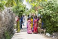 A Group of Hindu Indian Women Wearing Colorful Sari`s Walking Down a Street