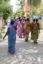 A Group of Hindu Indian Women Wearing Colorful Sari`s Walking Down a Street