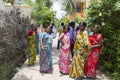 A Group of Hindu Indian Women Wearing Colorful Sari`s Walking Down a Street