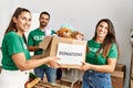 Group of hispanic volunteers smiling happy holding box with toys to donate at charity center Royalty Free Stock Photo