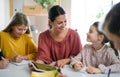 Group of homeschooling children with teacher studying indoors, coronavirus concept. Royalty Free Stock Photo