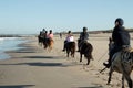 group of horse riders at the beach