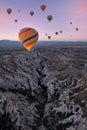 a group of hot air balloons over the rocky landscape of cappadocia at sunrise, the balloon in the foreground is illuminated by the Royalty Free Stock Photo