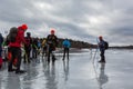 Group of ice skaters on wet melting ice with deep puddles. Royalty Free Stock Photo