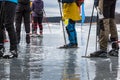 Group of ice skaters on wet melting ice on frozen lake taking a break. Late winter daytime in Sweden. Royalty Free Stock Photo