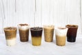 Group of iced coffee in plastic glass latte mocha yuzu espresso cappuccino americano are arranging in white wooden background