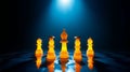 Illuminated chess pieces on a reflective surface under a spotlight in a dark environment setting Royalty Free Stock Photo