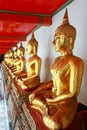 Group Images of Golden Buddha statue stucco in different posture in long corridor of Wat Phra Temple, Bangkok, Thailand Royalty Free Stock Photo