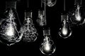 Group of incandescent light bulbs on black background with copy space. Generative AI Royalty Free Stock Photo