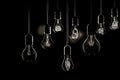 Group of incandescent light bulbs on black background with copy space. Generative AI Royalty Free Stock Photo