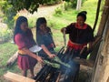 Group of indigenous women of Cofan nationality cooking maitos outside their house in the middle of the Amazon rainforest