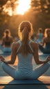 Group of individuals engaged in yoga outdoors, practicing meditation at sunset. Warm sunlight enhances the tranquil Royalty Free Stock Photo