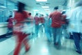 A group of individuals walking swiftly down a brightly lit hallway, their figures blending into a dynamic blur of Royalty Free Stock Photo