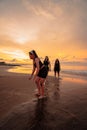 a group of Indonesian women doing ballet movement exercises together very flexibly on the beach