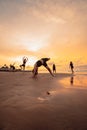 a group of Indonesian women doing ballet movement exercises together very flexibly on the beach