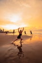 a group of Indonesian women doing ballet movement exercises together very flexibly on the beach