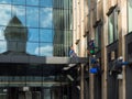 Group of industrial mountaineering workers hang over modern business building while washing exterior facade