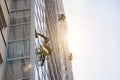 Group Industrial mountaineering workers in uniform washing exterior building glazing