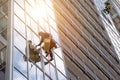 Group Industrial mountaineering workers in uniform washing exterior building glazing