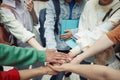 Group of intercultural teenage students in casualwear making pile of hands