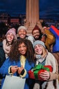 Vertical portrait of a group of friends with shopping bags and a christmas gift smiling and looking at camera. Happy Royalty Free Stock Photo