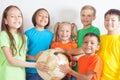 Group of international kids holding globe earth