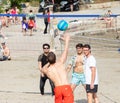 A group of international students from all over the world playing sand volleyball on the beach of bacvice in split. Man throwing a
