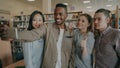 Group of international students have fun smiling and making selfie photos on smartphone camera at university library Royalty Free Stock Photo