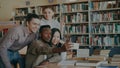 Group of international students have fun smiling and making selfie photos on smartphone camera at university library Royalty Free Stock Photo