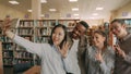 Group of international students have fun smiling and making selfie photos on smartphone camera at university library Royalty Free Stock Photo