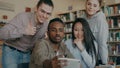 Group of international students have fun smiling and making selfie photos on smartphone camera at university library Royalty Free Stock Photo