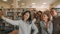 Group of international students have fun smiling and making selfie photos on smartphone camera at university library Royalty Free Stock Photo