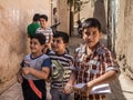 Group of iranian Pupils, boys, primary and secondary school students, standing and playing , one holding a study notebook, in Yazd