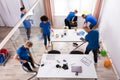 Group Of Janitors Cleaning Office With Cleaning Equipment Royalty Free Stock Photo