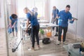 Group Of Janitors Cleaning Office With Cleaning Equipment