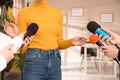 Group of journalists interviewing woman in room