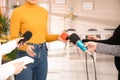 Group of journalists interviewing woman in room