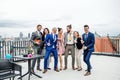 A group of joyful businesspeople having a party outdoors on roof terrace in city.