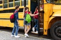 Group of joyful children eagerly getting on yellow school bus Royalty Free Stock Photo